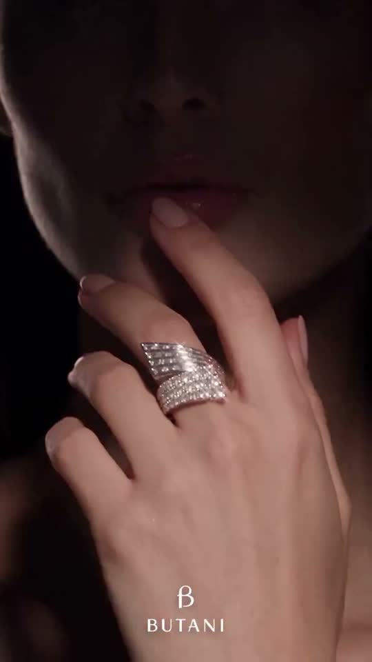 Hand wearing a diamond ring in low light