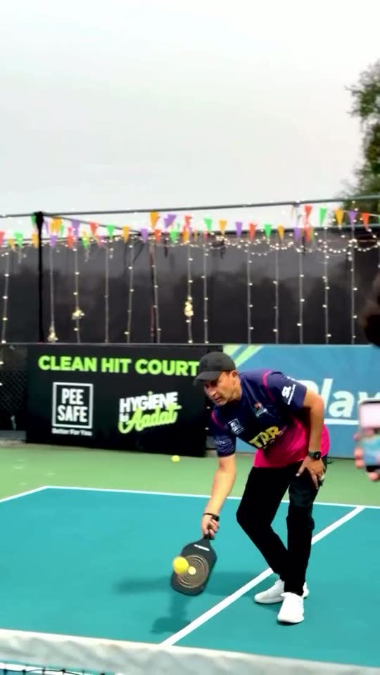 Player on a pickleball court with Pee Safe Clean Hit Court branding